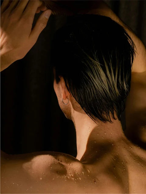 Man applying Eclat Soin Deep Cleanse Scalp Scrub with Keratin and Rosemary Oil to wet hair