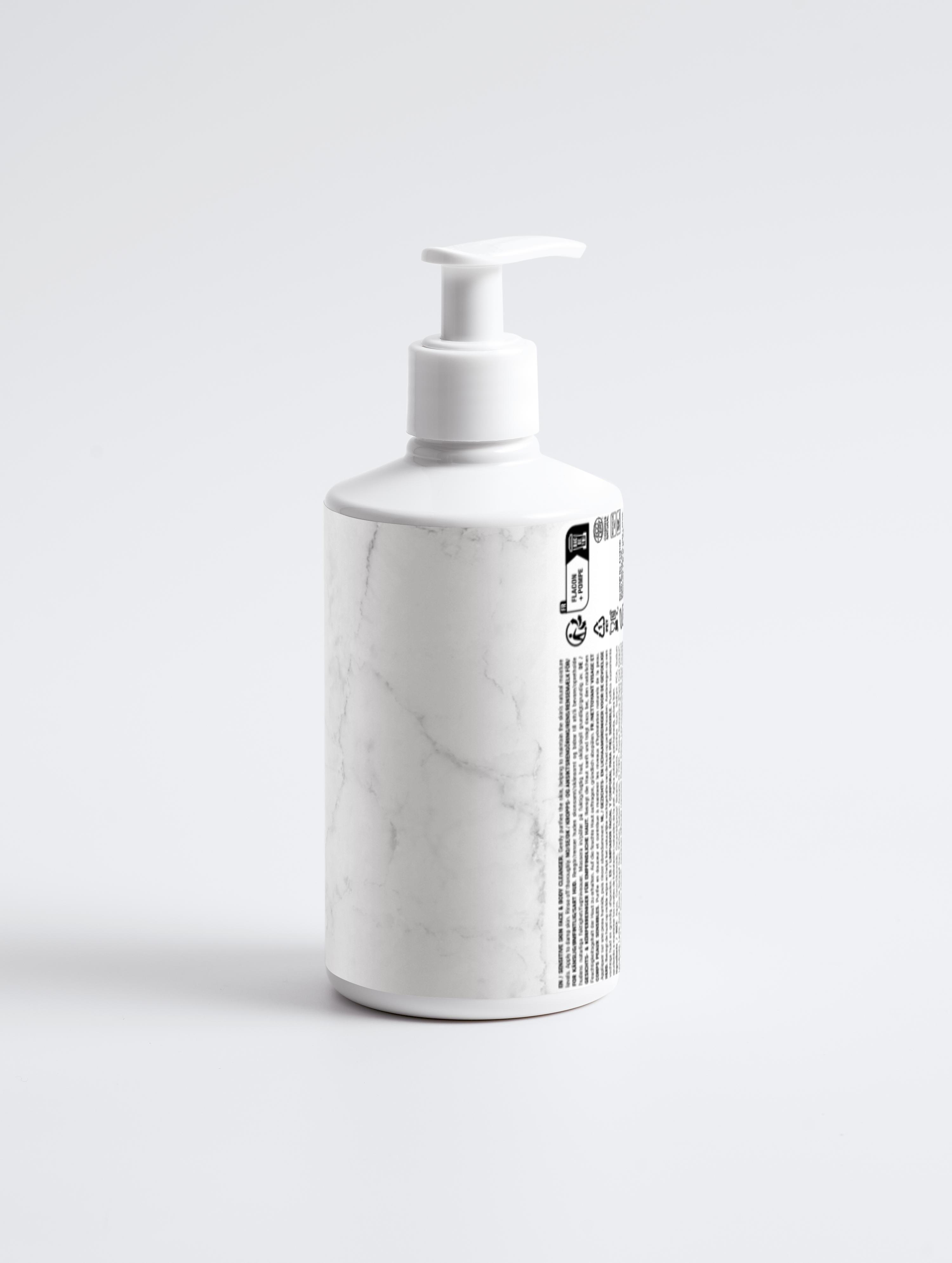 Eclat Soin Sensitive Skin Face & Body Cleanser in a marble-patterned bottle with a pump dispenser