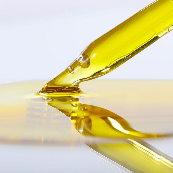 Eclat Soin softening beard oil in a glass dropper with a golden hue for beard hydration