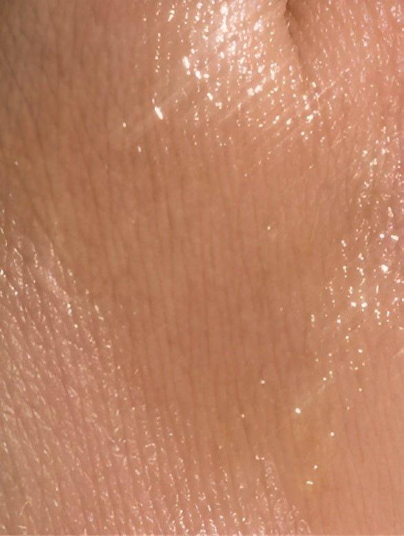 Close-up of Eclat Soin Organic Nourishing Facial Oil glistening on skin for radiant hydration